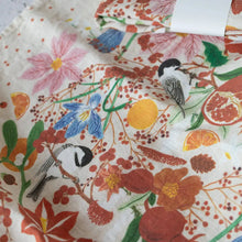 Vibrant floral bird print linen tea towel in oranges, reds, greens on white