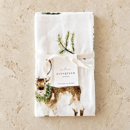 White cotton tea towel with a watercolor deer and greenery tied with a ribbon paired with african zulu trivet