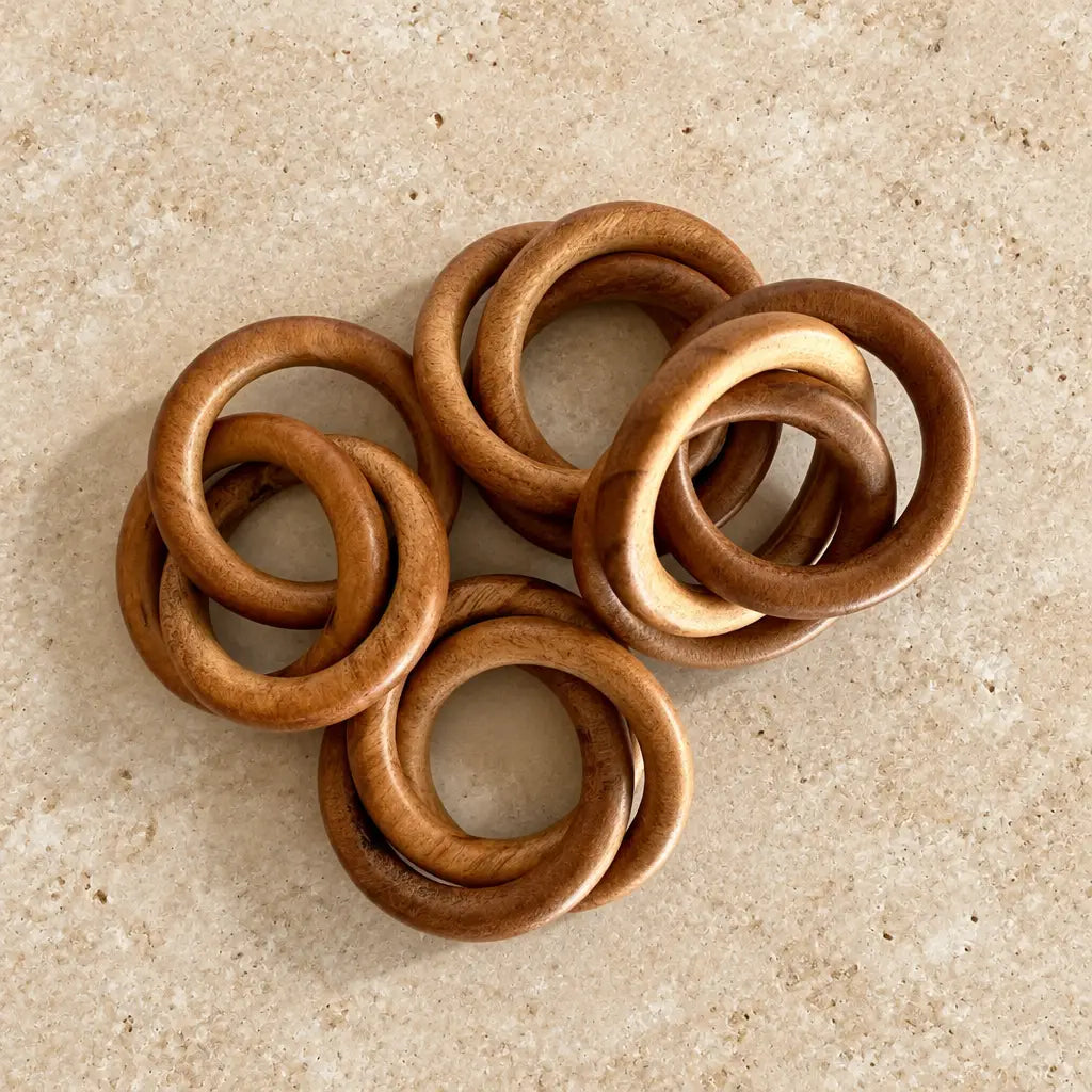 Set of six handcrafted wooden napkin rings with warm natural finish and smooth rounded edges as bangles napkin rings