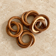 Set of six handcrafted wooden napkin rings with warm natural finish and smooth rounded edges as bangles napkin rings