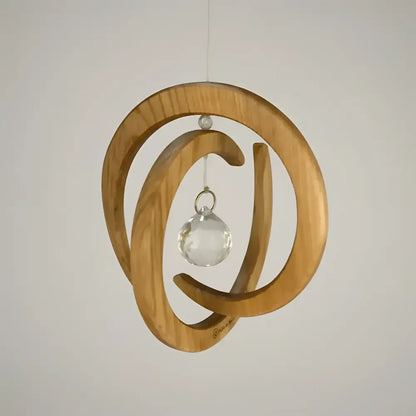 Handcrafted wood spiral ornament with circular design and clear crystal ball spinner in the center