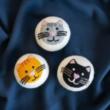 Three felted house cats dryer balls in gray, orange, black