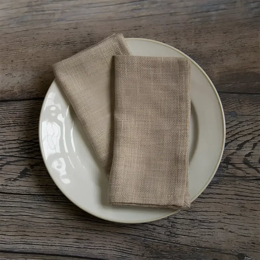 Two neutral colored cloth napkins on a plate.